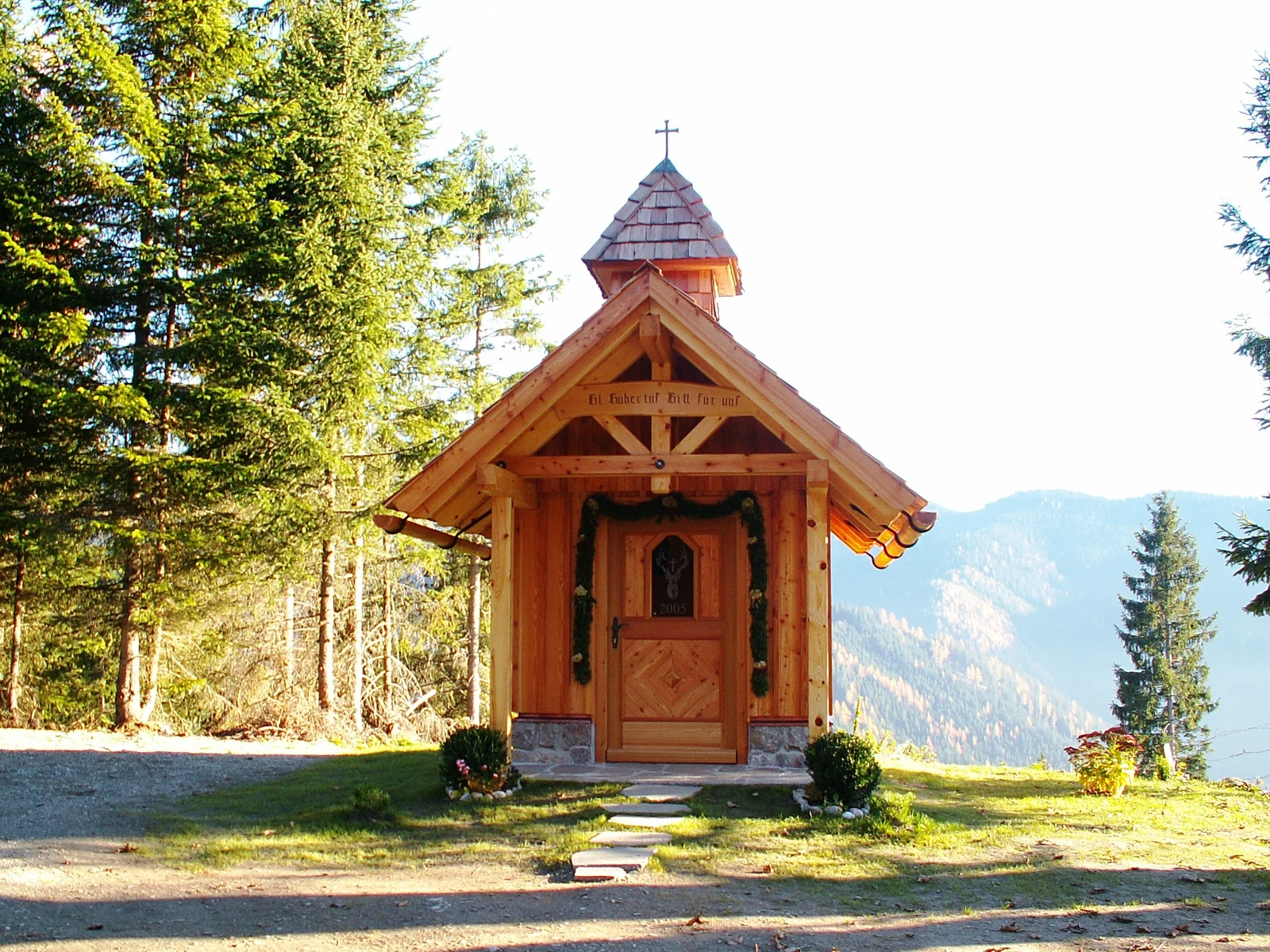 Kleine Holzkapelle vor einer Berglandschaft
